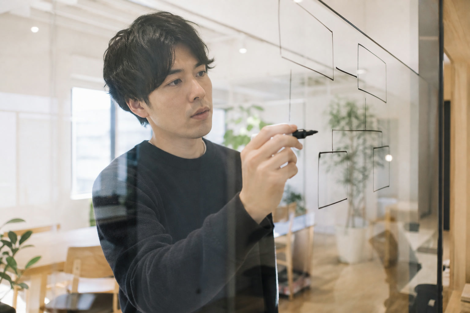 ガラスボードに図を描いている様子